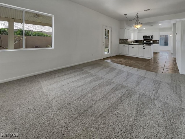 interior space featuring recessed lighting, dark tile patterned flooring, visible vents, baseboards, and dark colored carpet