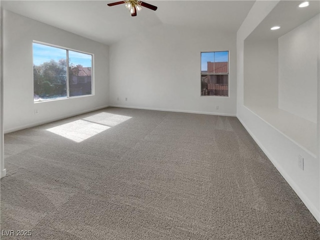 empty room with carpet flooring, a ceiling fan, and baseboards