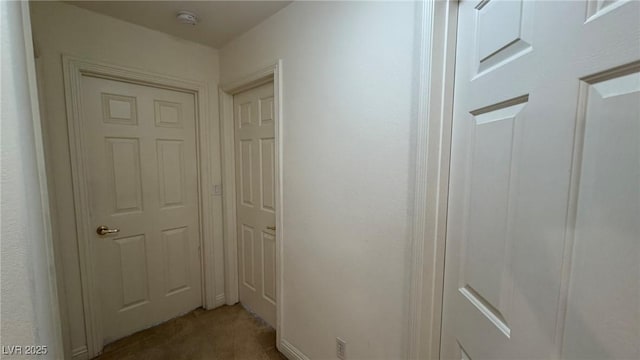 hallway with dark colored carpet