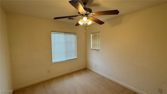 unfurnished room with light colored carpet, visible vents, ceiling fan, and baseboards