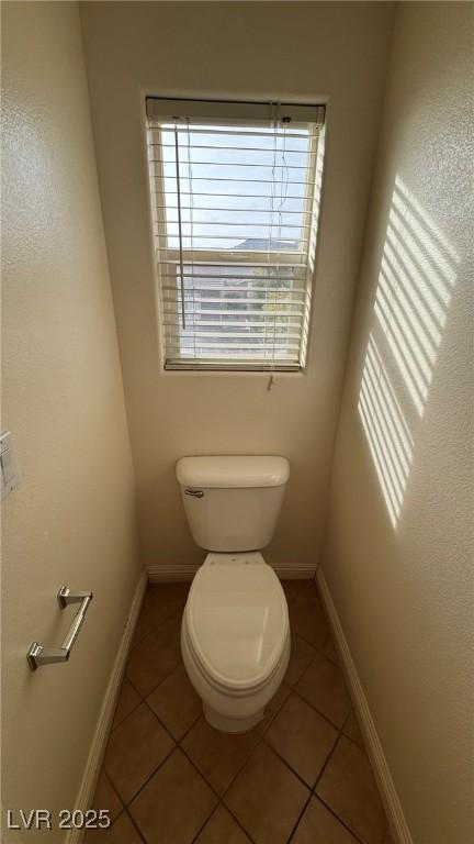 bathroom with baseboards, toilet, and tile patterned floors