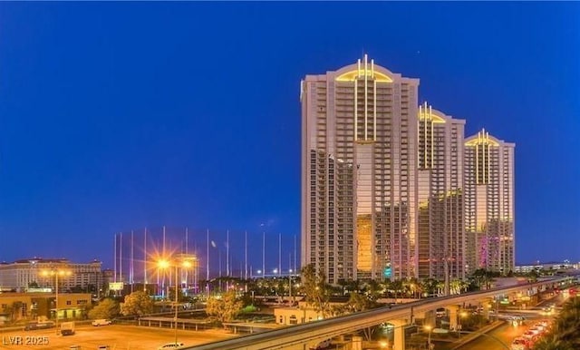 property at twilight with a view of city lights