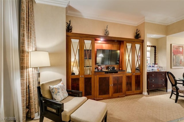 living area with baseboards and crown molding