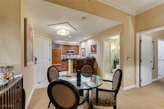 dining space with recessed lighting, crown molding, and baseboards