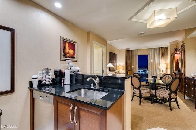 kitchen with dark stone counters, brown cabinets, white dishwasher, light floors, and a sink