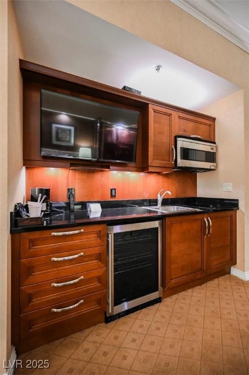 bar with ornamental molding, wine cooler, stainless steel microwave, and baseboards