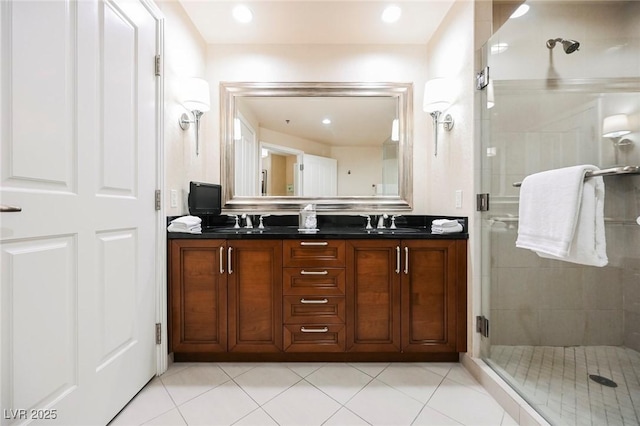 bathroom featuring double vanity, tile patterned flooring, a shower stall, and a sink