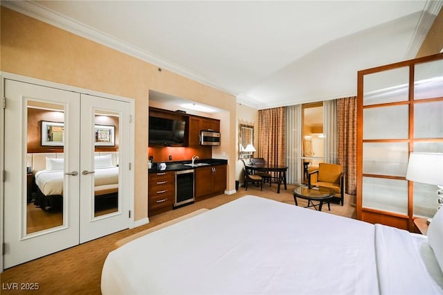 bedroom with light colored carpet, wine cooler, crown molding, french doors, and a sink