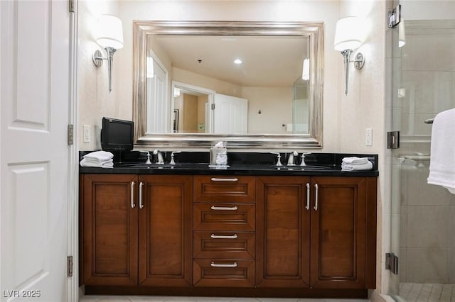 bathroom with double vanity, a stall shower, and a sink