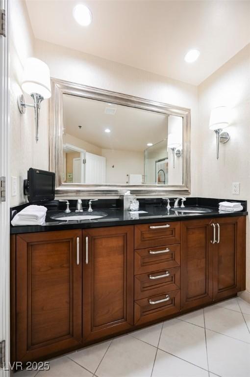 bathroom with double vanity, a sink, and tile patterned floors