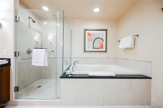 bathroom featuring a bath, a stall shower, and vanity