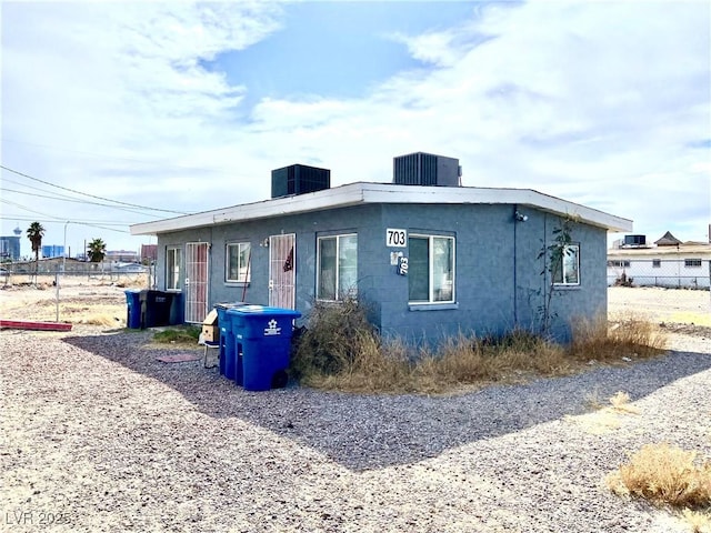 view of front of property featuring cooling unit and fence