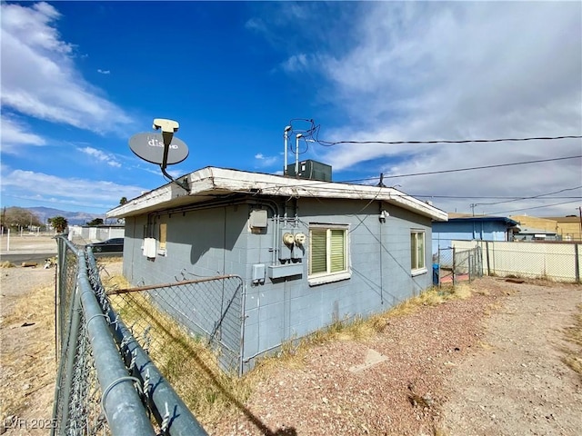 view of home's exterior featuring fence and concrete block siding