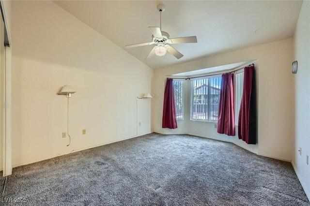 carpeted spare room featuring vaulted ceiling and ceiling fan