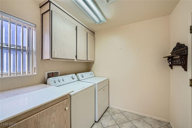 laundry room featuring light tile patterned flooring, independent washer and dryer, cabinet space, and baseboards