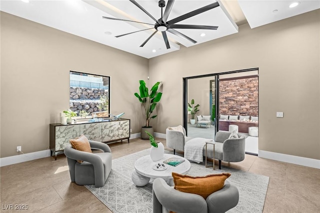 living room with baseboards, ceiling fan, and recessed lighting