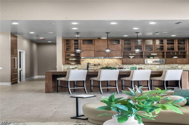 kitchen with decorative backsplash, modern cabinets, a kitchen bar, glass insert cabinets, and open shelves