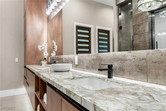 bathroom featuring double vanity, a tile shower, and a sink