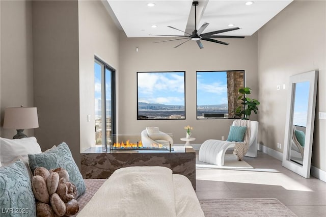 living area featuring recessed lighting, baseboards, and ceiling fan