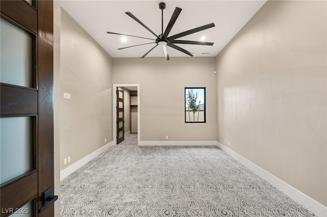 spare room featuring a ceiling fan, carpet floors, and baseboards