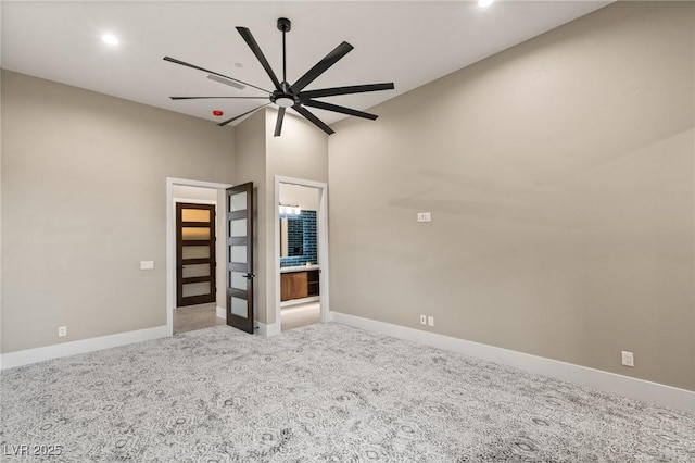 empty room with baseboards, a ceiling fan, and light carpet