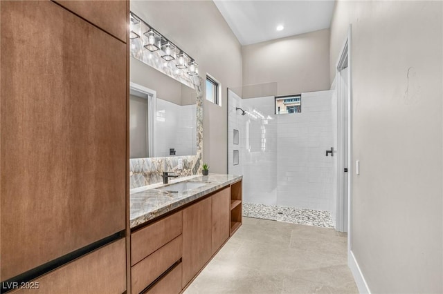 bathroom with vanity, baseboards, and a walk in shower