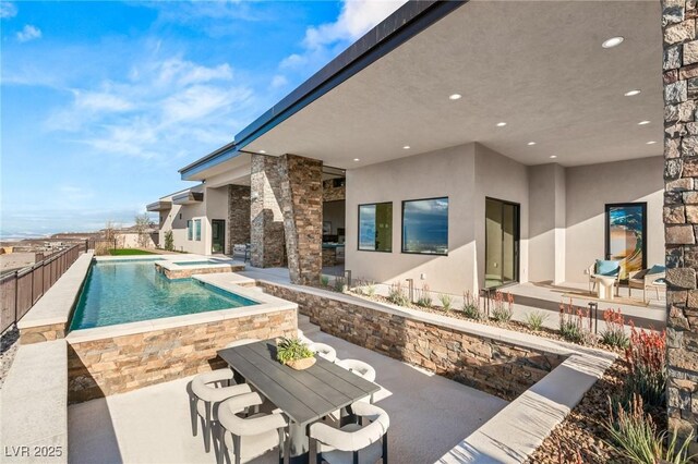 view of pool with fence, a fenced in pool, an in ground hot tub, and a patio area