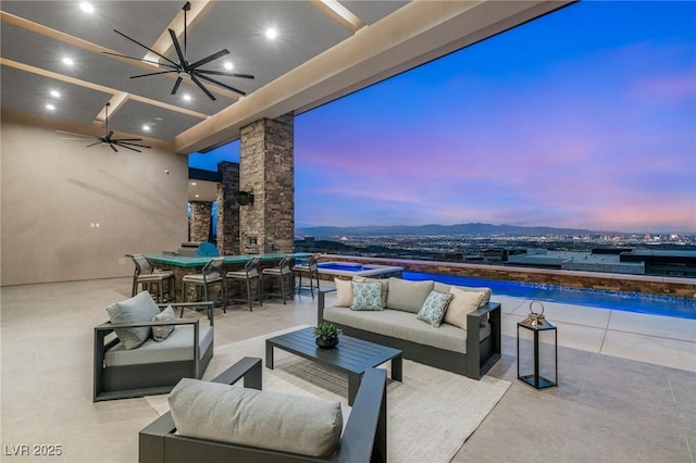 patio terrace at dusk featuring an outdoor pool, an outdoor hangout area, a hot tub, outdoor dining space, and a ceiling fan
