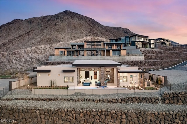 back of house with a patio area, stucco siding, fence, and a mountain view