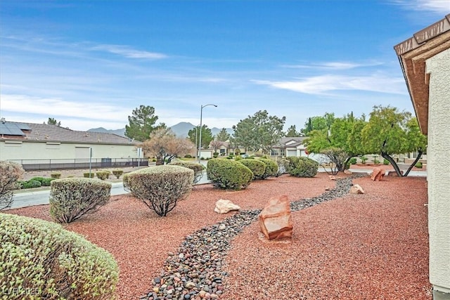 view of yard with a residential view, fence, and a mountain view