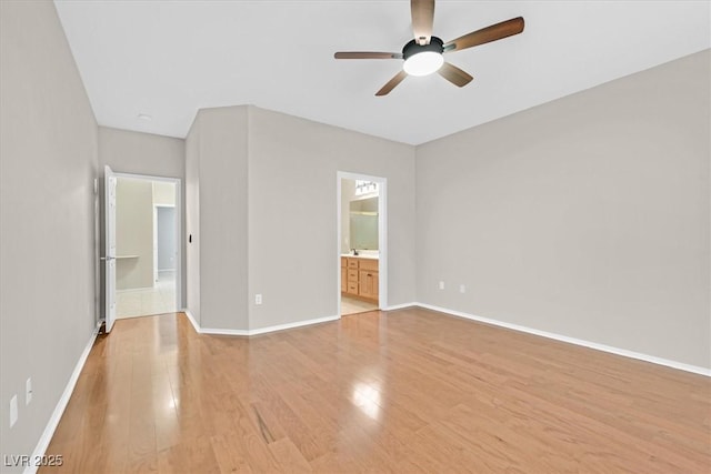 unfurnished bedroom with ceiling fan, light wood-style flooring, baseboards, and ensuite bathroom