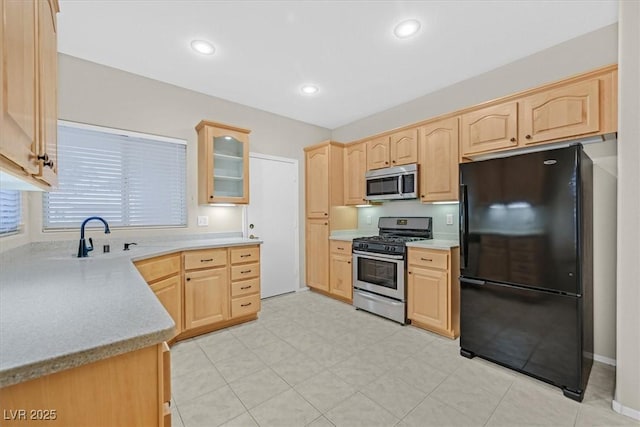 kitchen featuring a sink, appliances with stainless steel finishes, and light brown cabinets