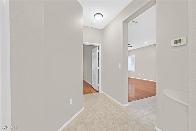 hall with baseboards and light tile patterned floors