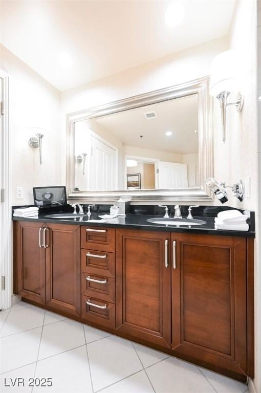 full bath featuring double vanity, tile patterned flooring, and a sink