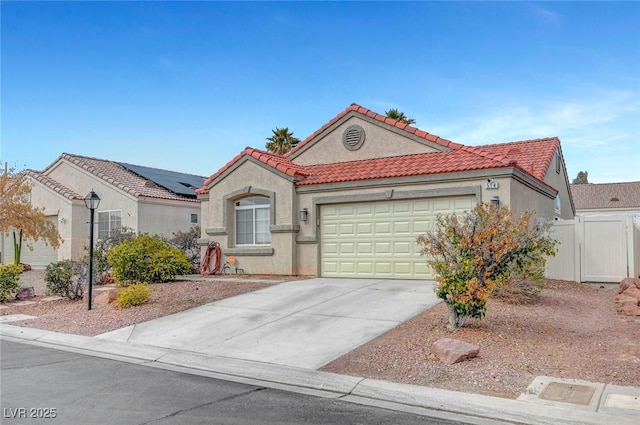 mediterranean / spanish house featuring a garage, a tile roof, driveway, a gate, and stucco siding