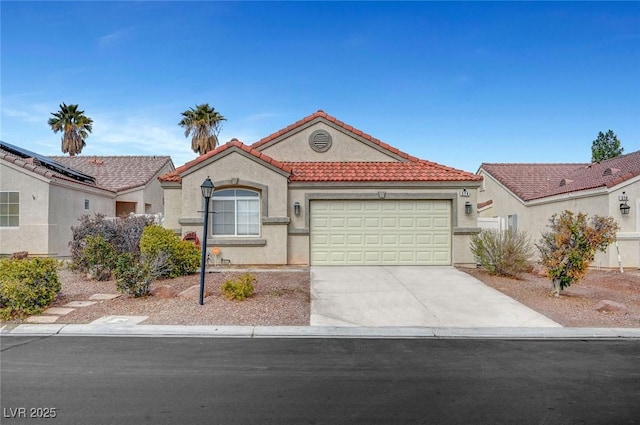 mediterranean / spanish-style house featuring driveway, an attached garage, a tile roof, and stucco siding