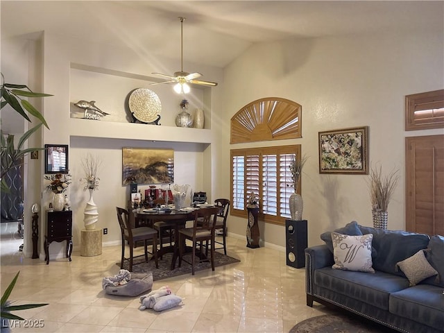 dining room featuring baseboards, high vaulted ceiling, and a ceiling fan