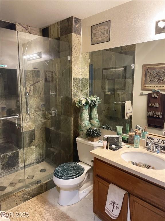 full bathroom with toilet, a shower stall, and vanity