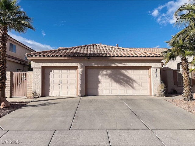 garage with driveway and a gate