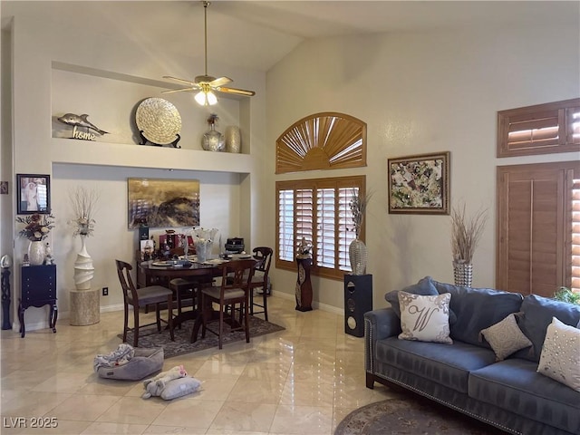 dining space with baseboards, high vaulted ceiling, and ceiling fan