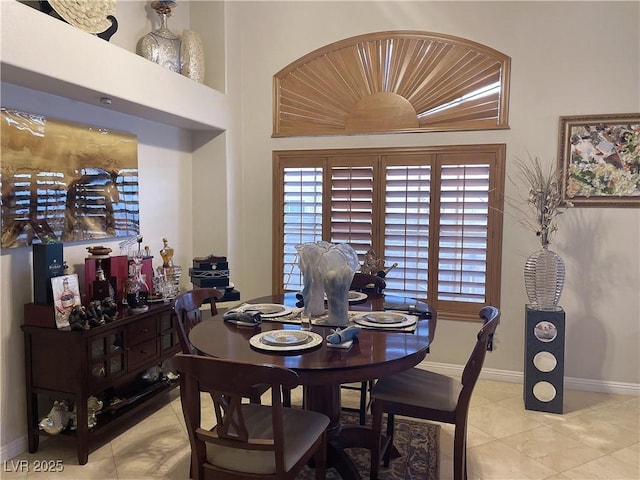 dining area featuring light tile patterned floors and baseboards