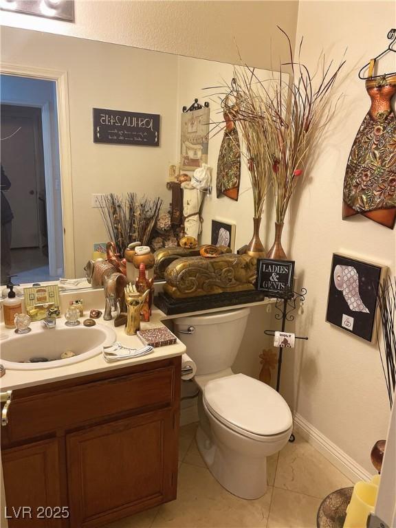 bathroom featuring toilet, tile patterned flooring, baseboards, and vanity