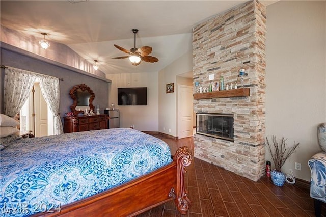 bedroom with lofted ceiling, ceiling fan, wood finish floors, a fireplace, and baseboards