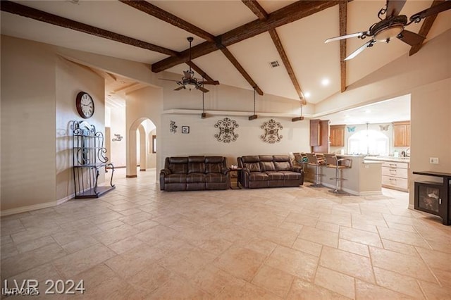 living room with visible vents, arched walkways, a ceiling fan, beamed ceiling, and high vaulted ceiling