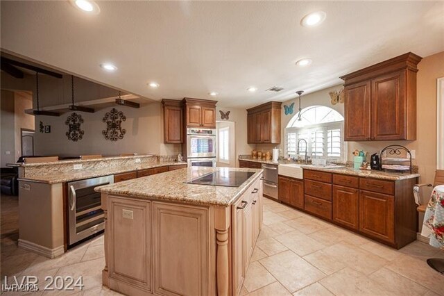 kitchen with beverage cooler, a kitchen island, a peninsula, black electric stovetop, and stainless steel double oven