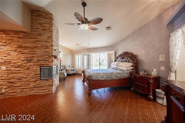 bedroom featuring a ceiling fan, visible vents, a fireplace, and wood finished floors