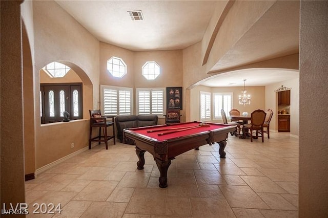 recreation room with arched walkways, visible vents, and plenty of natural light