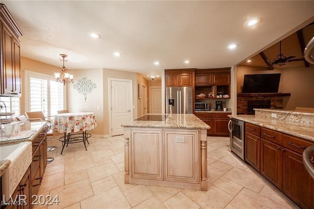 kitchen with a center island, pendant lighting, recessed lighting, appliances with stainless steel finishes, and beverage cooler