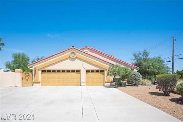 mediterranean / spanish home with driveway, a tiled roof, a garage, and stucco siding