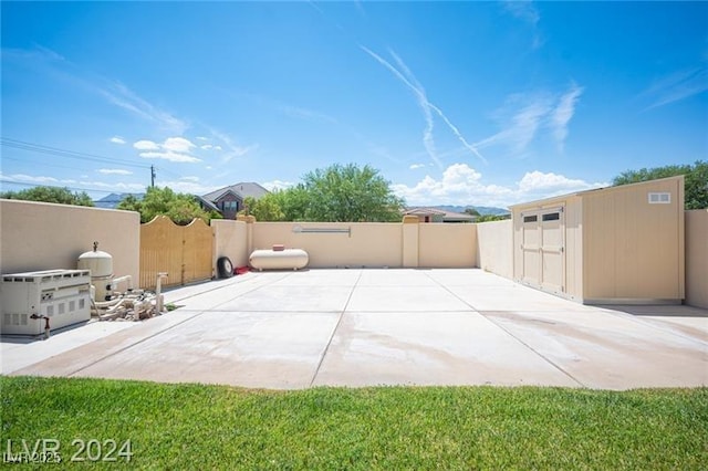 view of patio featuring a fenced backyard, an outdoor structure, visible vents, and a storage shed